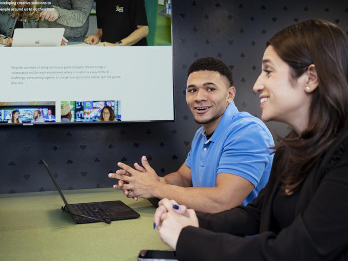 a man and woman sitting at a table with a laptop