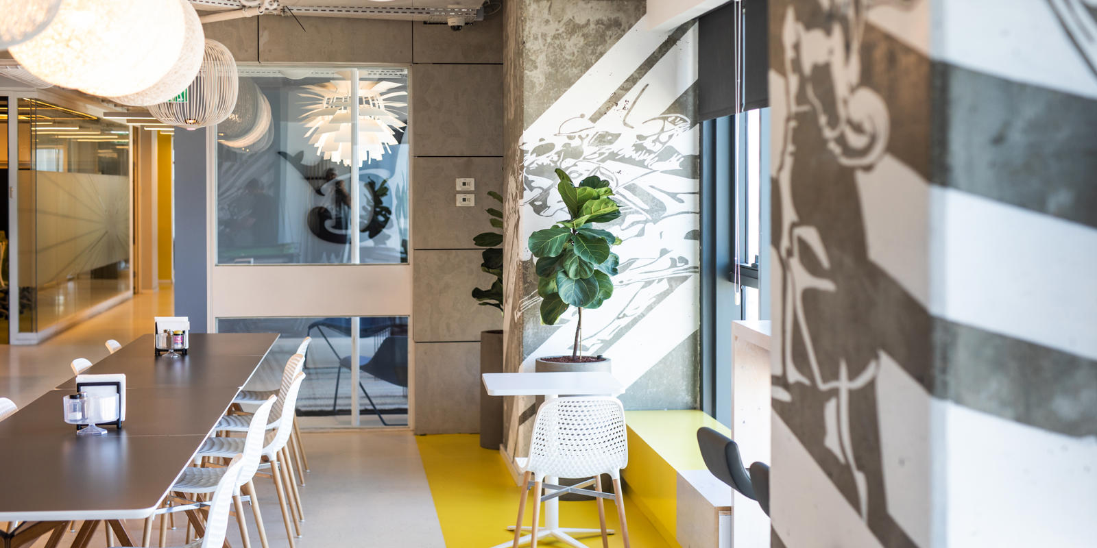 a room with a table and chairs and a plant