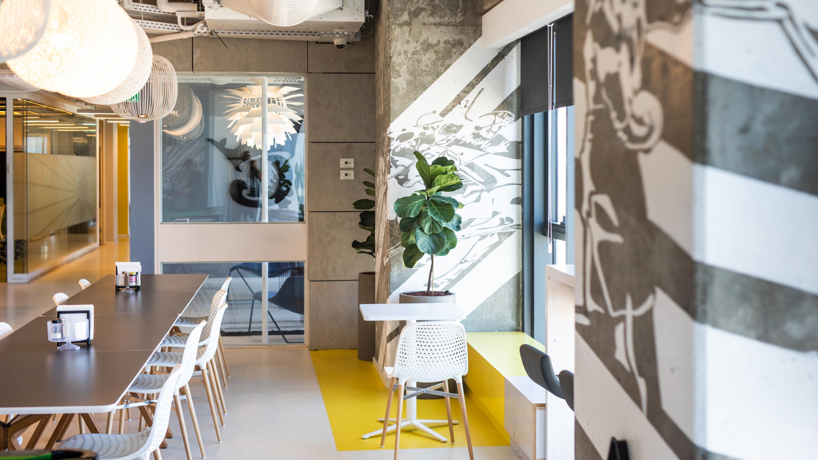 a room with a table and chairs and a plant