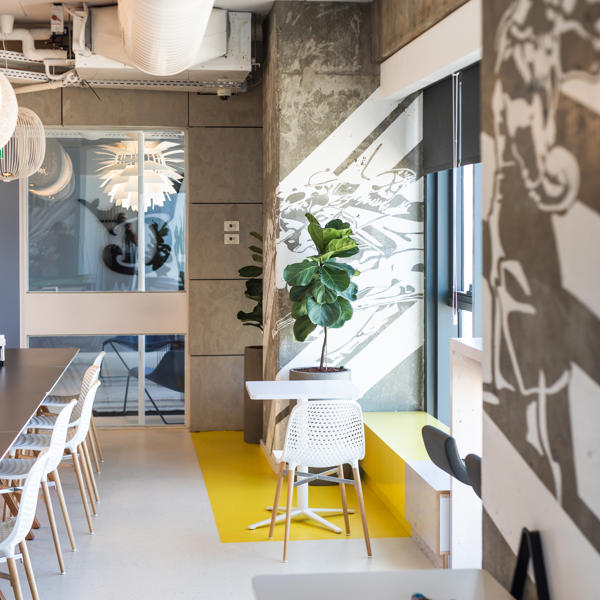 a room with a table and chairs and a plant