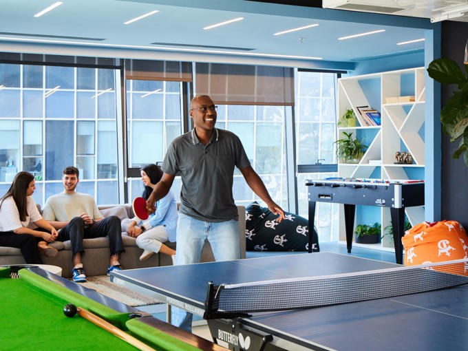 a man standing in front of a ping pong table