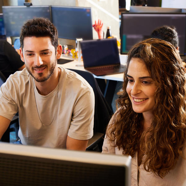 a man and woman looking at a computer screen