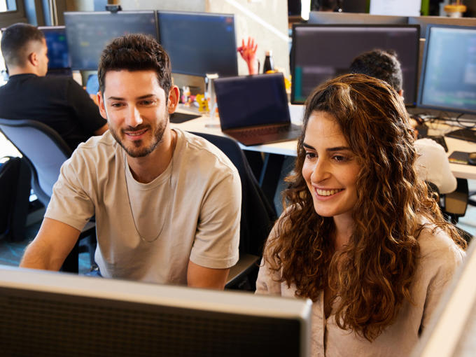 a man and woman looking at a computer screen