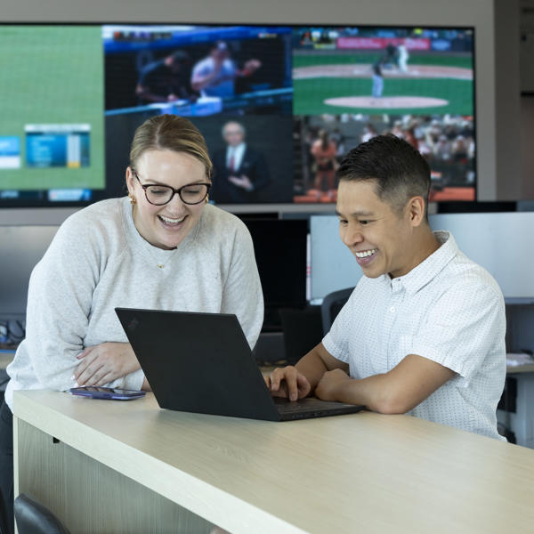 a man and woman looking at a laptop