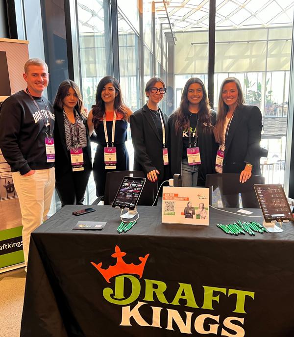a group of people standing in front of a table with a table with a sign