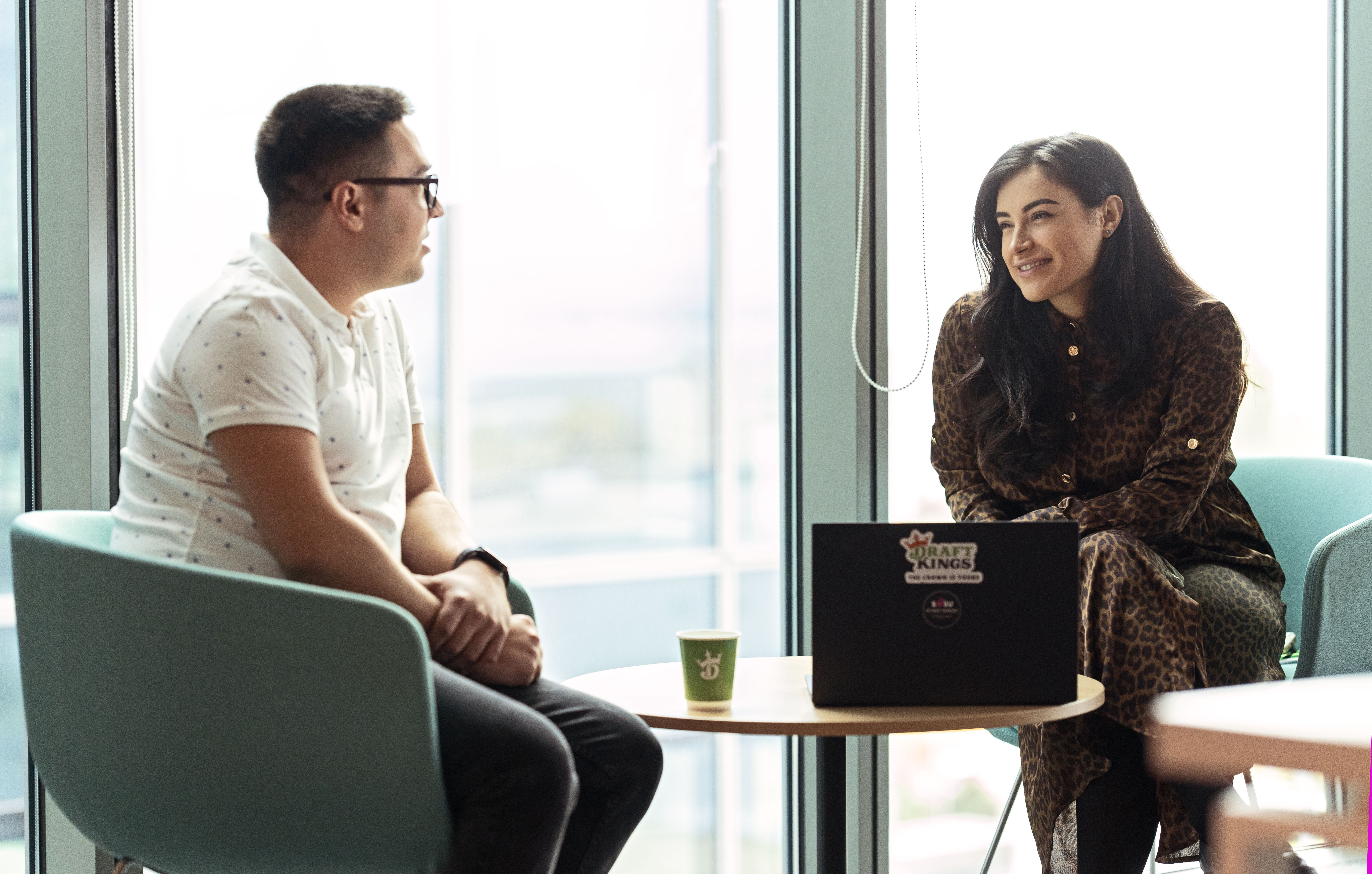 a man and woman sitting at a table looking at each other
