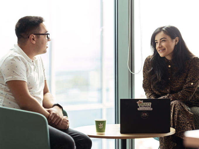 a man and woman sitting at a table looking at each other