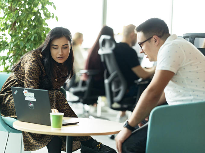 a man and woman looking at a laptop