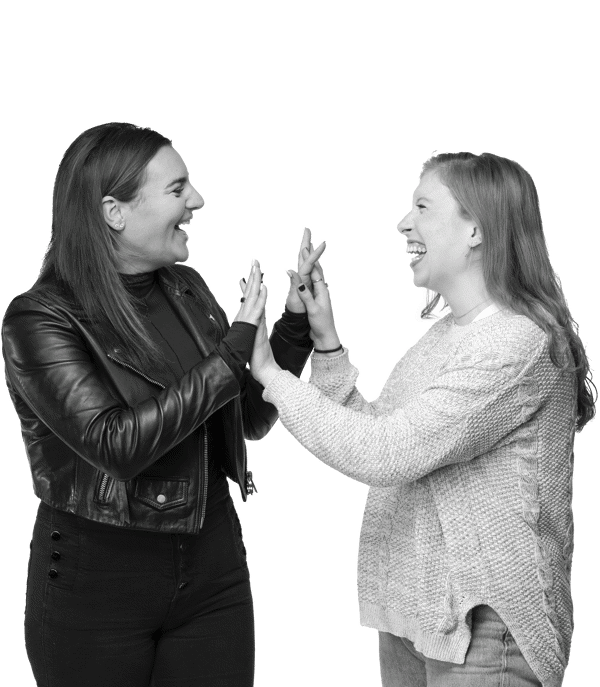 two women standing together and giving each other a peace sign