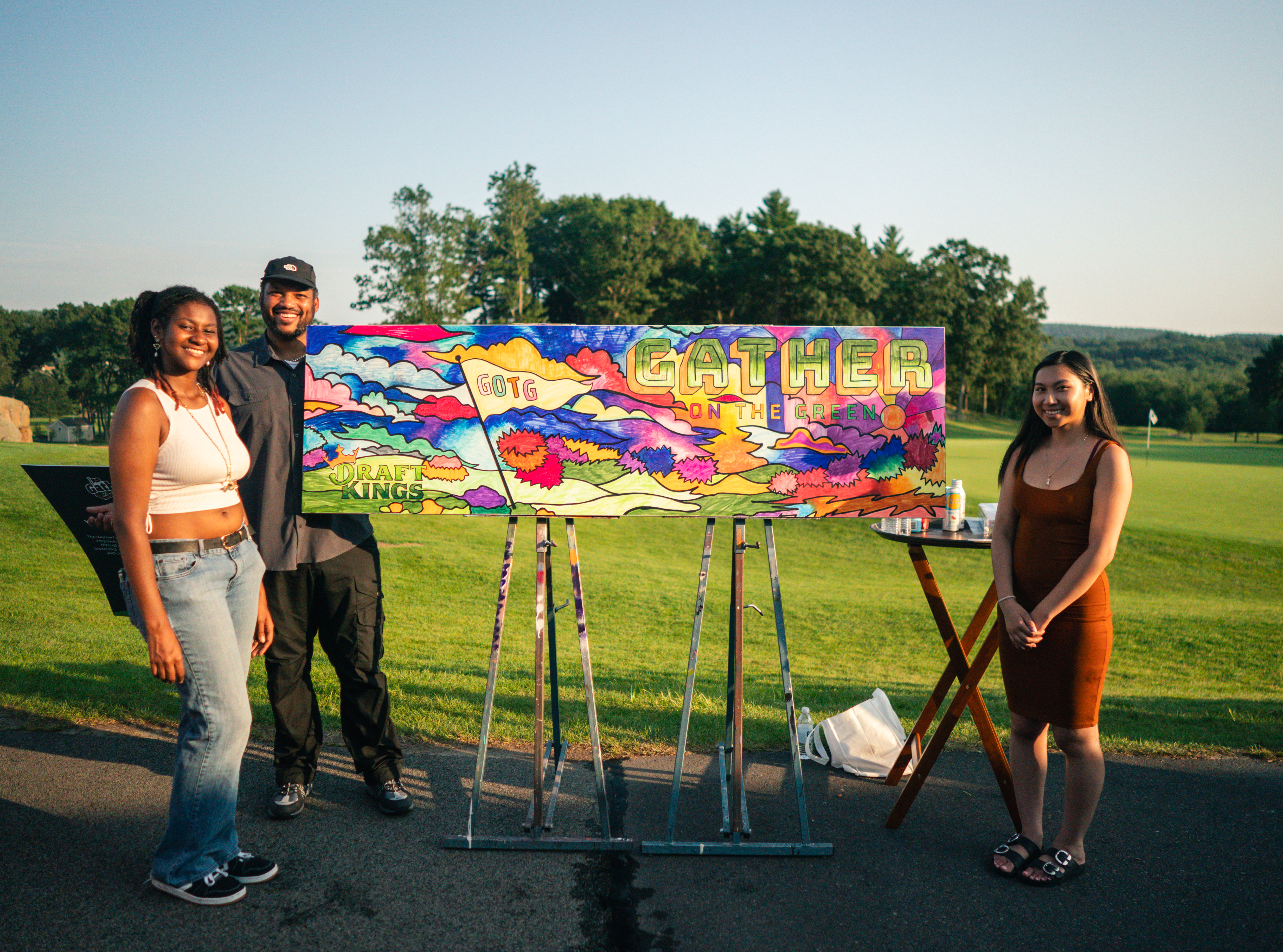 a group of people standing next to a painting